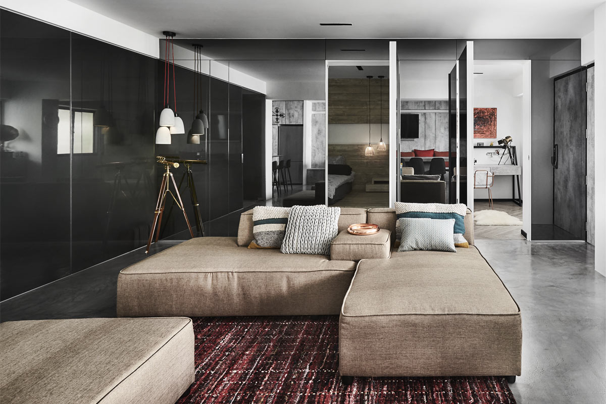Creating a communal space where conversations can flow freely, the living room is characterised by two large comfy sofa sets. On the surrounding walls, a combination of mirrored and high-gloss surfaces help to visually expand the space.