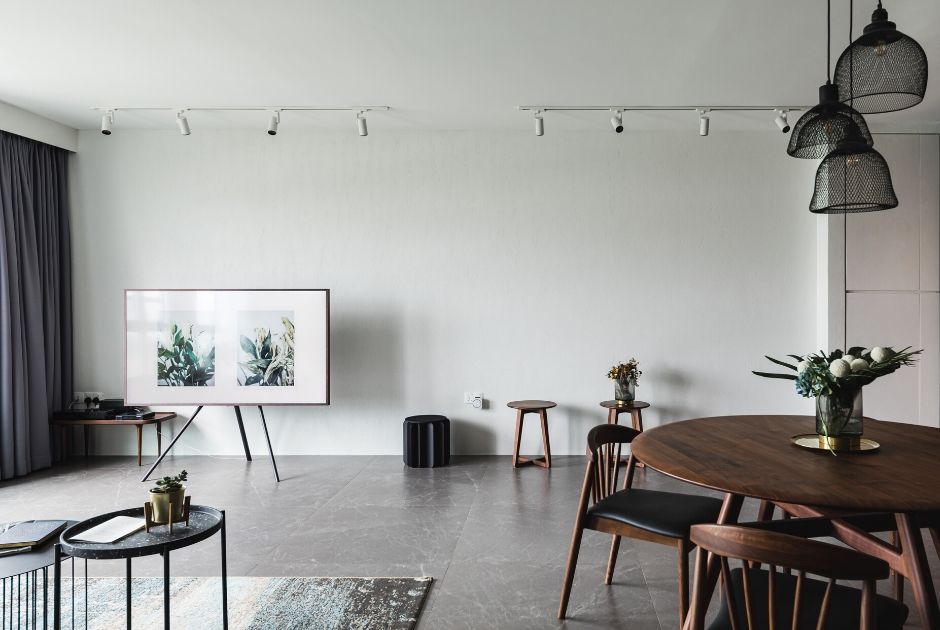 LIVING ROOM: Grey marble-lookalike floor tiles and a smattering of wood furnishings and fabric furniture help in softening the spartan appearance of the surrounding whitewashed surfaces in the living room. 
