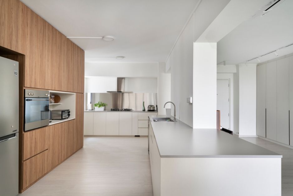 KITCHEN: Decked in a pared-back colour palette of light-coloured cabinetry and quartz worktops, the kitchen has an enduring and easy-to-maintain material ensemble; especially with the stainless steel backsplash.
