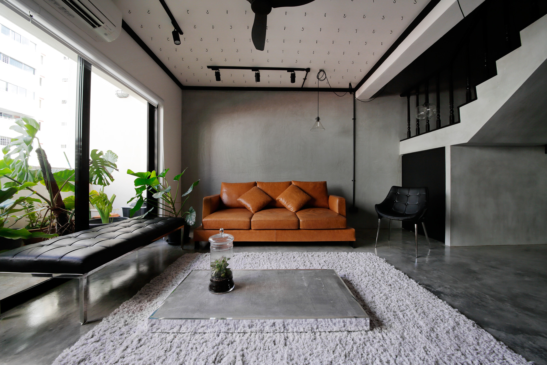 squarerooms-free-space-intent-living-room-grey-orange-bright-couch-balcony-plants