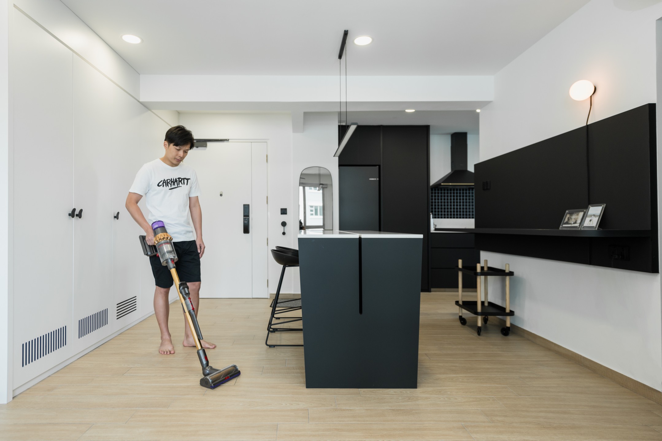 squarerooms-dyson-home-appliance-lifestyle-monochromatic-sleek-man-cleaning-vacuum-kitchen