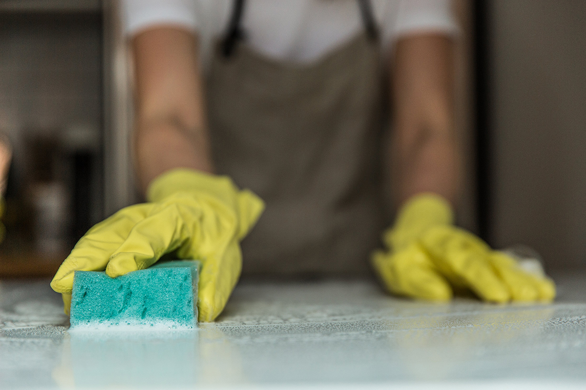squarerooms-man-hands-sponge-cleaning-countertop-kitchen