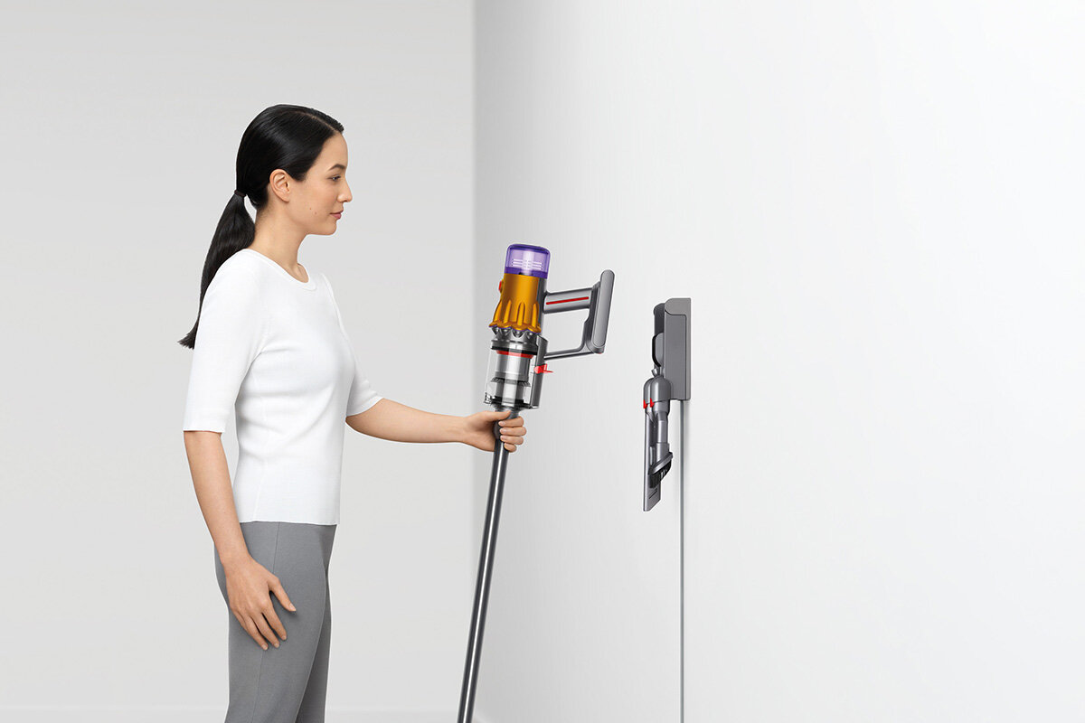 squarerooms dyson v12 detect slim total clean vacuum new launch release appliance cleaning device woman placing vacuum on charging dock station wall