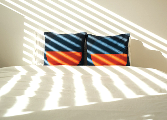 squarerooms Jakub Chlouba Unsplash white bed sheets cushions blue orange