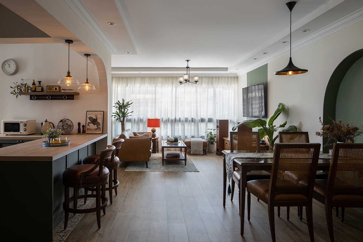 squarerooms fifth avenue interior home renovation interior design boho tropical look jungalow aesthetic 4 room hdb flat in bishan living dining room green wall paint feature curved oval rounded arch rustic vietnamese wood furniture open concept space kitchen island blue cabinets