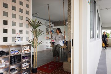 squarerooms knock knock studio interior design home renovation industrial eclctic style 4 room resale hdb flat makeover look entryway homeowner sitting on swing breezeblocks
