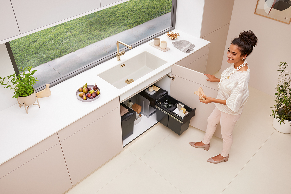 blanco subline kitchen organisation system blanco unit fittings cream minimalist modern cabinets woman throwing away trash